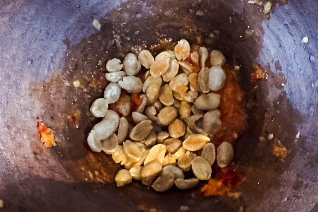 Som tam thai – peanøtter tilsettes for støting i morter