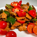 Pad ped moo - svinenakke-wok med rød curry Pad ped moo - ferdig rett